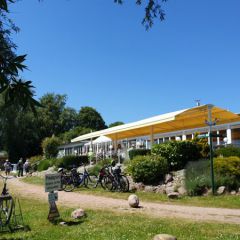 Inselhof Vineta - Achterwasserseite mit Terrasse und Raedern von Gaesten des Ausflugsrestaurants