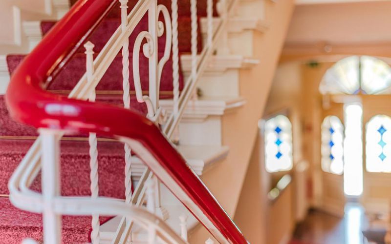 Treppenhaus der Strandvilla Residenz mit rotem Gelaender